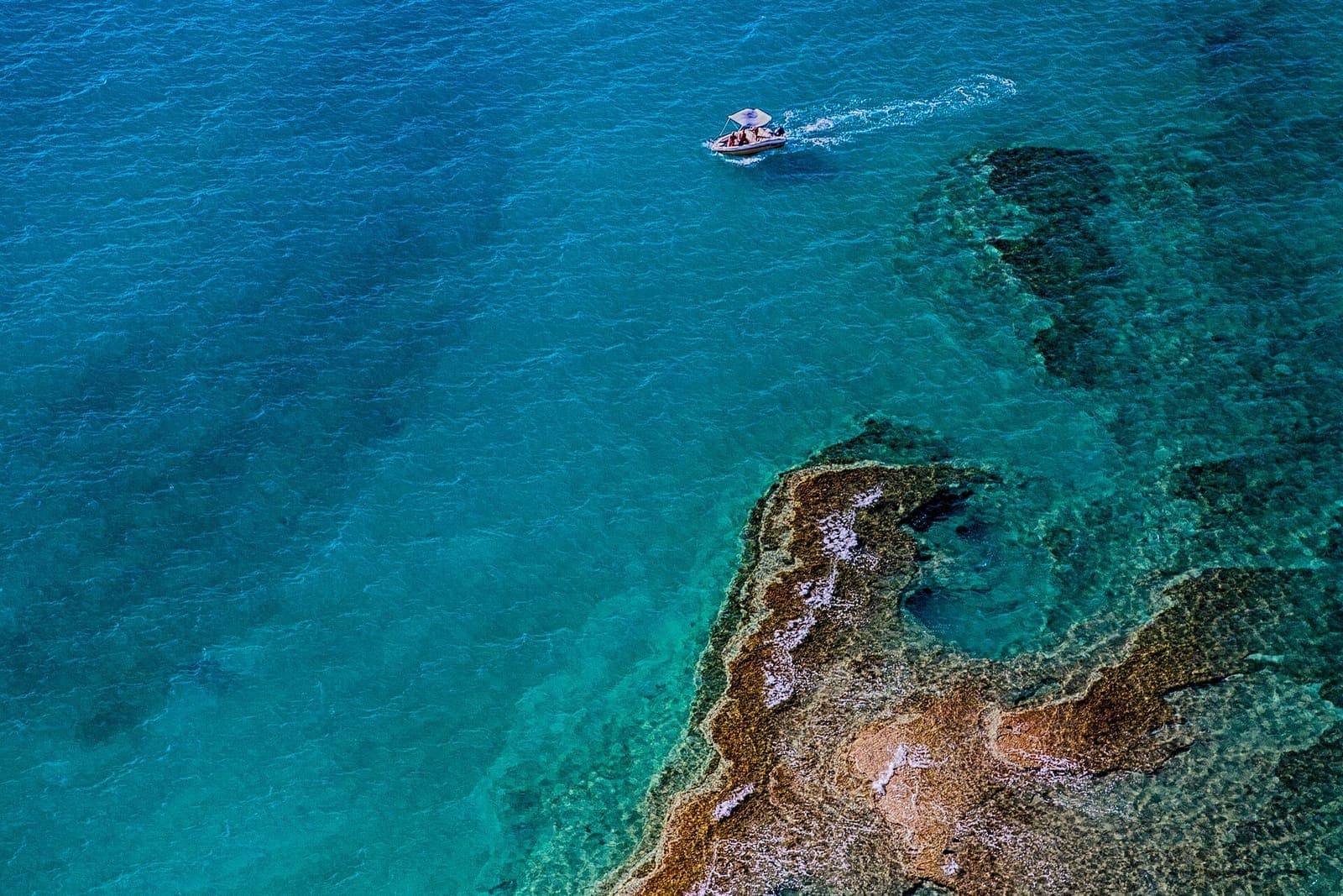 Motorboat over a shallow reef in clear turquoise water