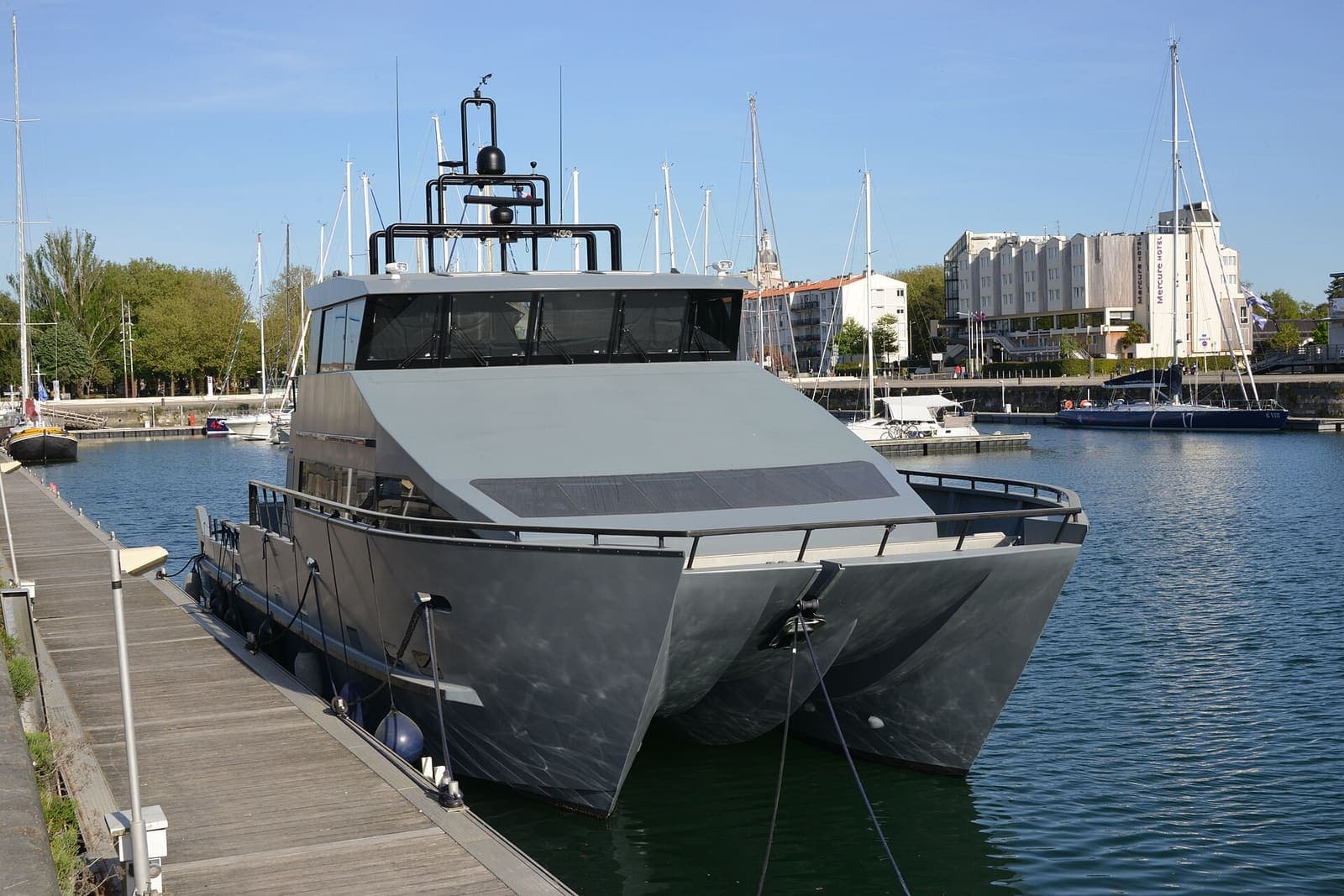 Modern power catamaran moored alongside a pontoon